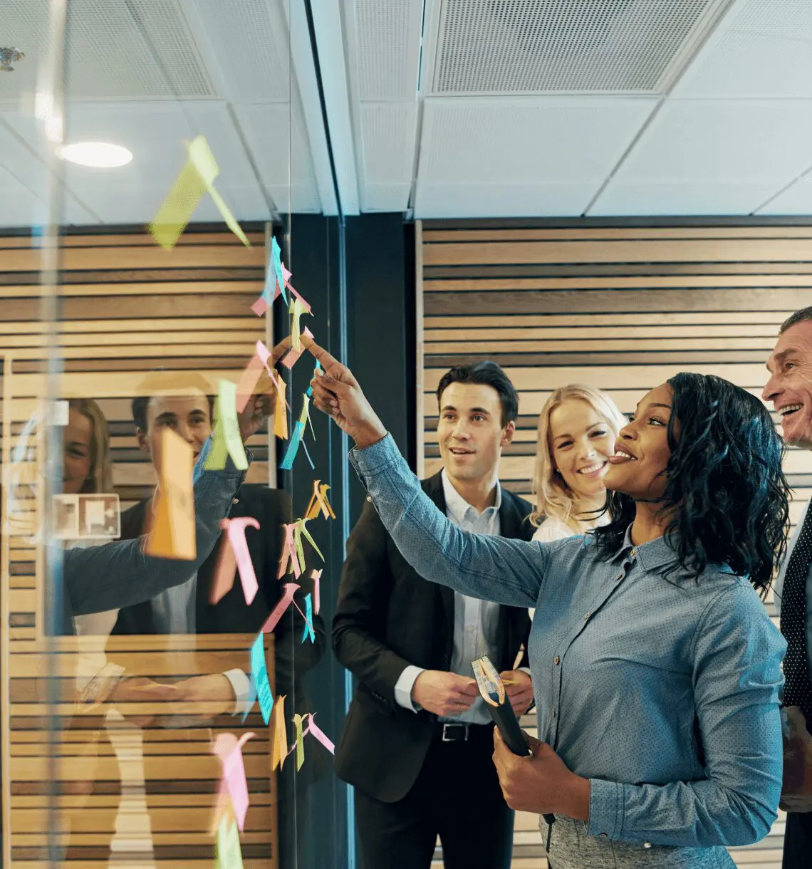 Team brainstorming ideas on glass wall.