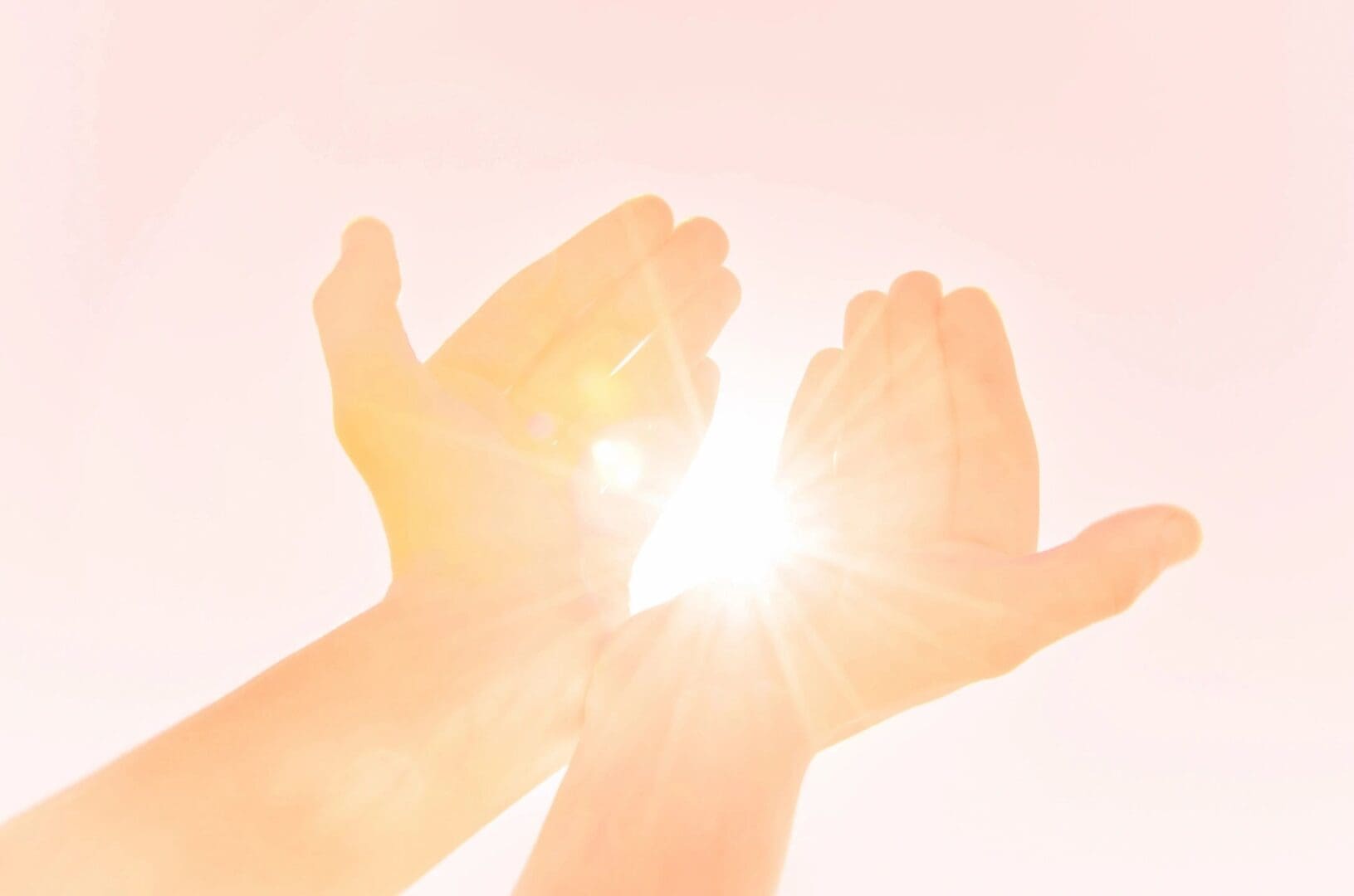 A person 's hands are open and the sun is shining.