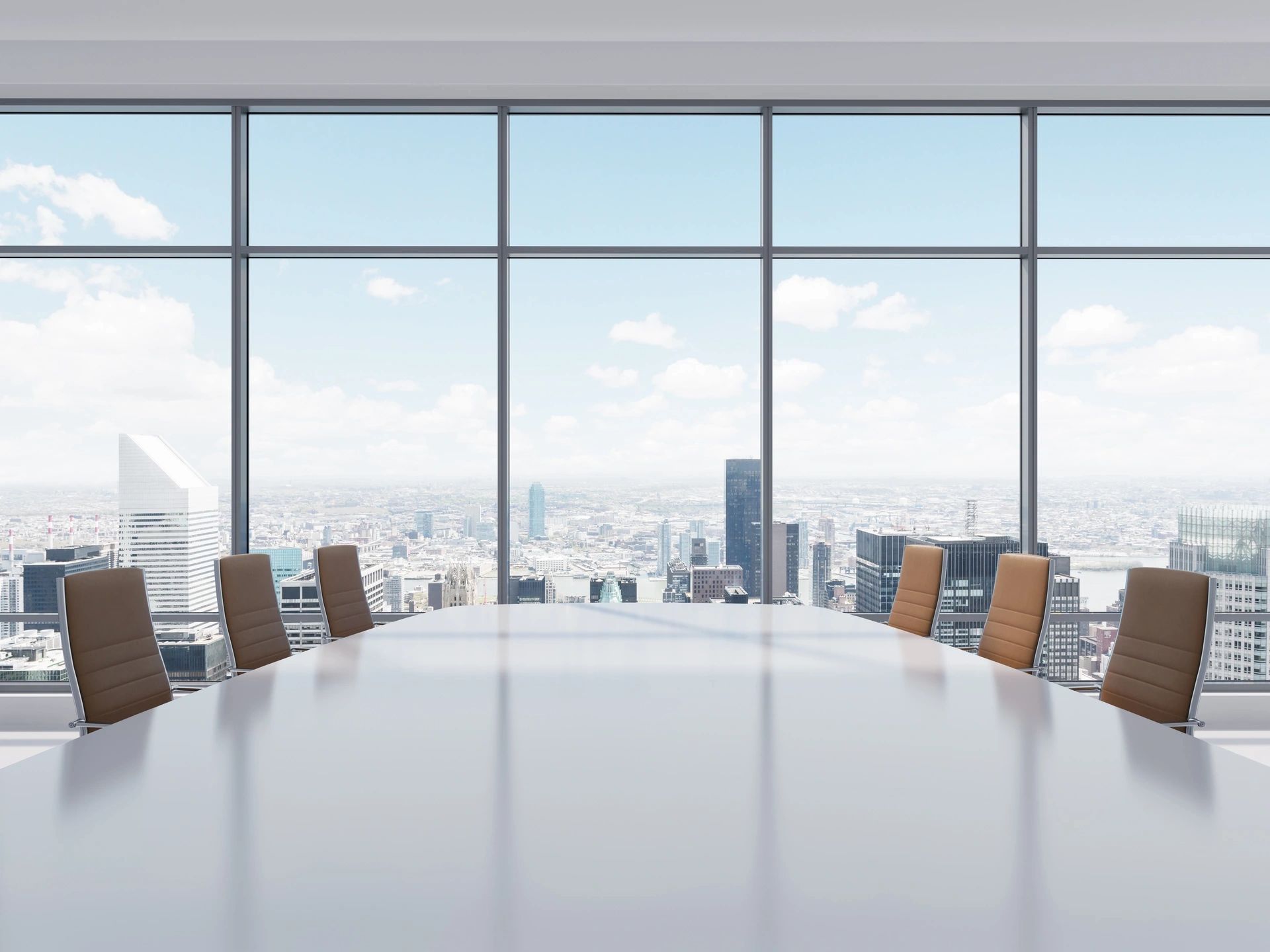 A conference table with chairs in front of a large window.