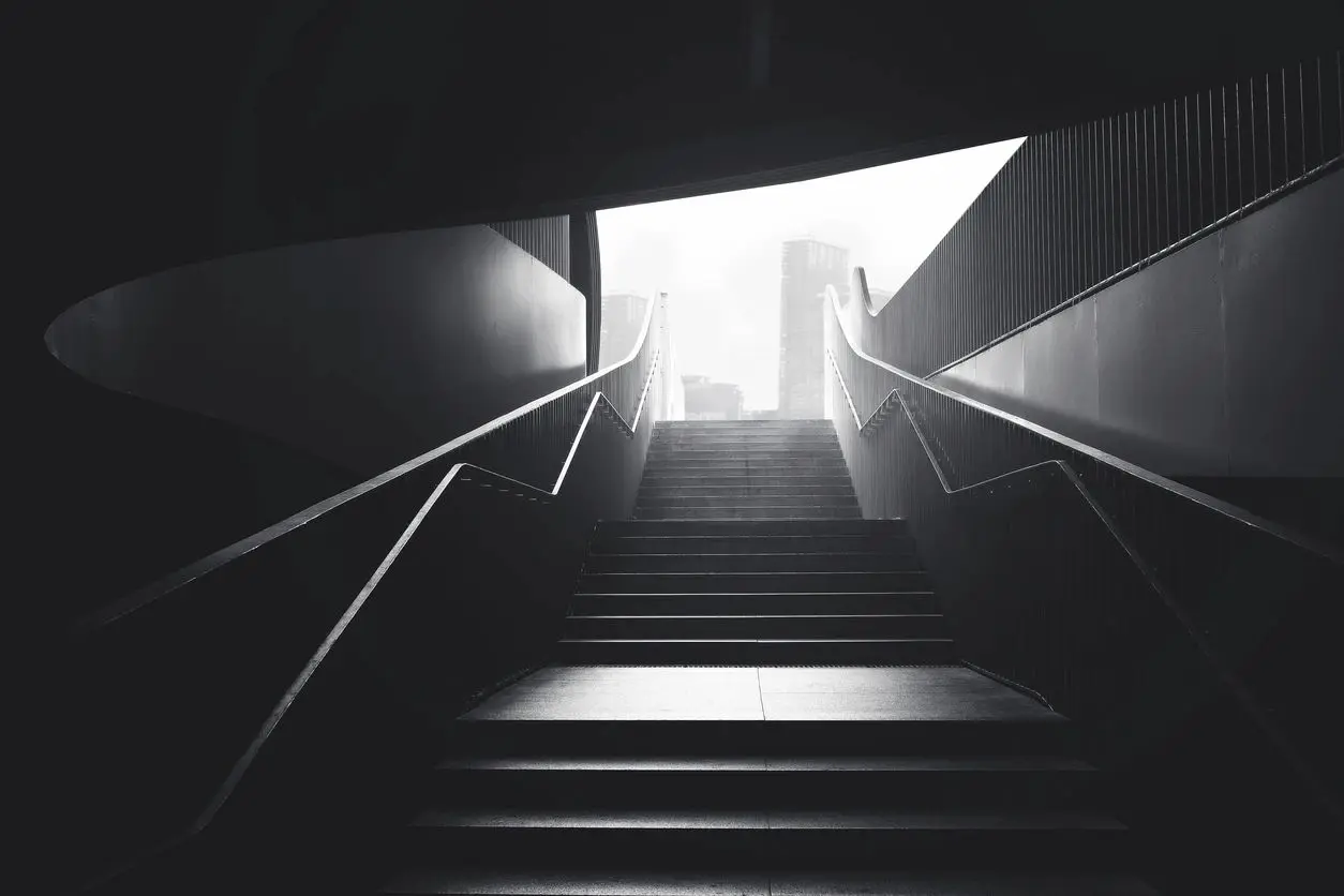 A black and white photo of some stairs leading to the top