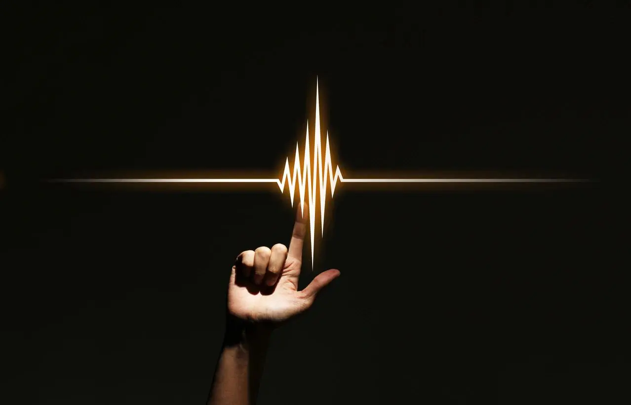 A hand is touching an audio wave.